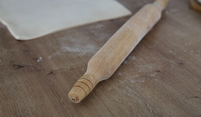Classic wooden rolling pin with freshly prepared dough
