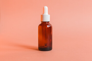 Different serum cosmetic bottles, white and dark brown dropper bottle container and packaging skincare product. studio pastel light background.