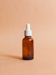 Different serum cosmetic bottles, white and dark brown dropper bottle container and packaging skincare product. studio pastel light background.