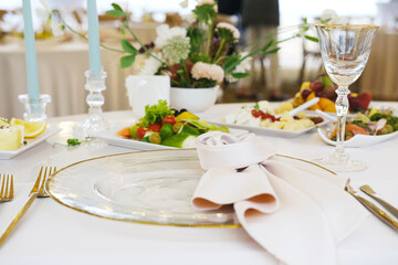 Fototapeta premium Elegant dining table setting with fine glassware, decorative plates, fresh vegetables, and floral centerpiece, creating a sophisticated atmosphere for special occasions