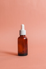 Different serum cosmetic bottles, white and dark brown dropper bottle container and packaging skincare product. studio pastel light background.