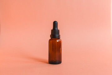 Different serum cosmetic bottles, white and dark brown dropper bottle container and packaging skincare product. studio pastel light background.