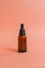 Different serum cosmetic bottles, white and dark brown dropper bottle container and packaging skincare product. studio pastel light background.