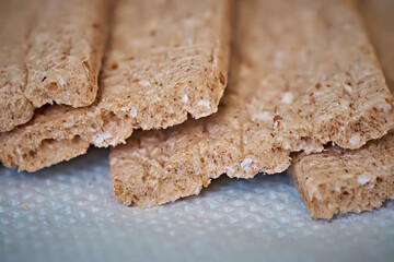 Crispy whole grain crispbread on a white napkin, top view. Healthy eating