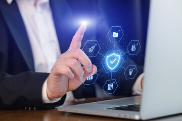 Person uses laptop to interact with virtual icons displaying security and data features in a professional setting