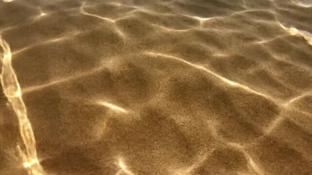 Sunlight dancing on sandy beach surface
