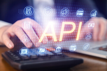 Hands working on calculator with API symbols displayed on screen in office environment
