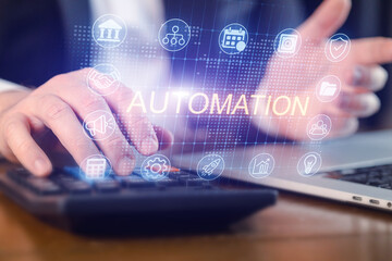 Hands using calculator with automation icons displayed on screen in office setting