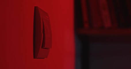 Red lit light switch on a wall close up