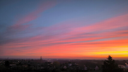 Obraz premium colorful sky at sunrise with aircraft trails in December above Petrovaradin