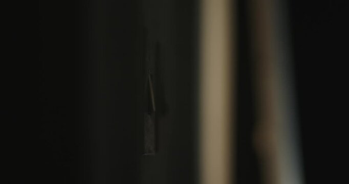 A human hand flips a switch on the white wall in the room