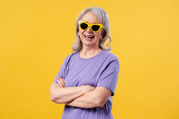 Fototapeta premium Senior woman laughing, wearing yellow sunglasses, expressing happiness and joy
