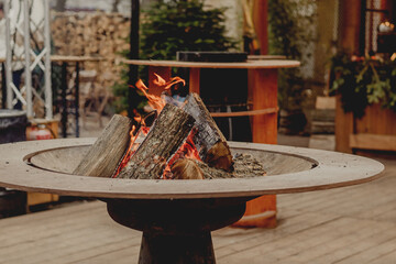 Outdoor Fire Pit with Burning Logs in Cozy Cafe Terrace