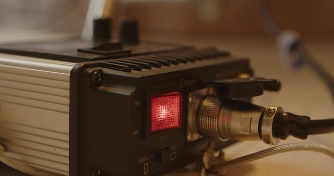 Powered studio light controller with red illuminated switch and cable connector