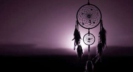 Serene Dream Catcher Silhouette Hanging at Dusk with Radiant Purple Sunset Sky Backdrop