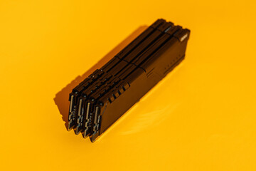 Stack of black RAM modules standing on yellow background. High quality photo
