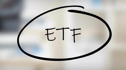 A person's hand actively writing and circling the acronym 'ETF' on a transparent glass surface, symbolizing key investment concepts in a professional business environment.