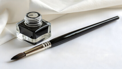 A Fine Art Brush and Ink Well Placed on a White Surface