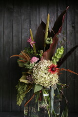 Beautiful bouquet of wildflowers on a black background, dark photo. Vertical photo.