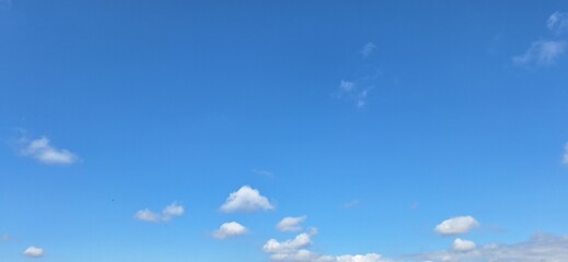 Beautiful blue sky with fluffy white clouds and copy space for background