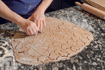 Cutting gingerbread cookies with cutters &ndash; holiday baking