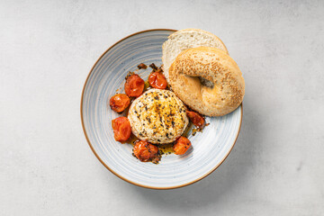 Baked cheese with roasted cherry tomatoes and sesame bagel