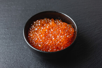 Black bowl with red caviar.