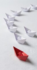 Red Paper Boat Stands Out From White Origami Boats in a Row