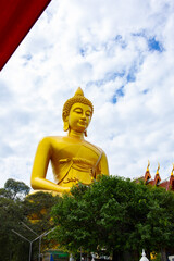 Golden Buddha at Wat Paknam temple in Bangkok, Thailand, front view on a sunny day