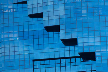 Geometric protruding balconies or terraces on the glass facade of a modern building