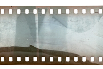 Dusty and grungy 35mm film texture or surface. Perforated scratched camera film isolated on white background.