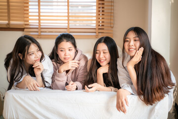 Beautiful asian woman friend happy gossip talking on bed and use smartphone