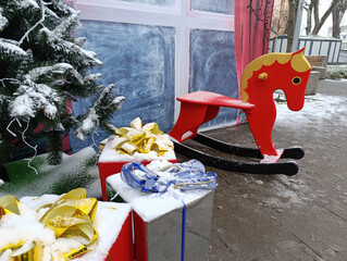 Christmas interior with red rocking horse, gifts and winter decor