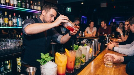 Bartender man pouring cocktail from shaker at bar counter. Group of friends enjoying drinks at a nightclub or pub.