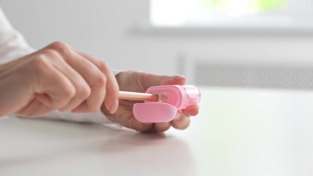 Hand using pink pencil sharpener at desk
