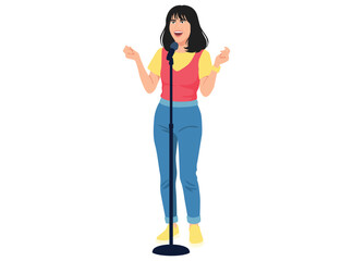 smiling female performer with dark hair stands at a microphone, energetically gesturing while singing or doing stand up comedy.