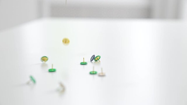 Colorful Push Pins Scattered on White Surface