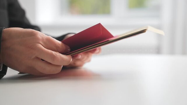 Hands Holding an Envelope with Red Card Inside