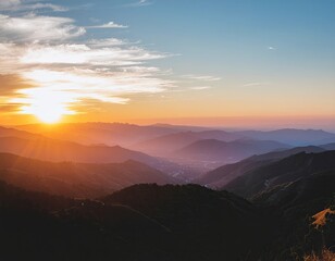 Golden Sun Setting Over Misty Mountain Range With Hazy Horizon And Distant Town Lights