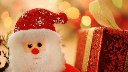 Cute Santa Claus with red gift box and Christmas bokeh lights
