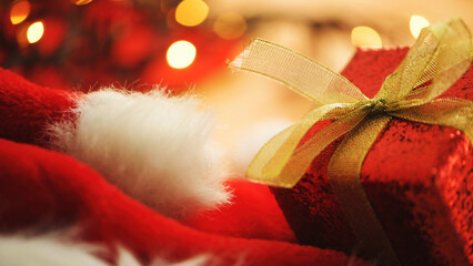 Sparkling red Christmas gift box tied with elegant gold ribbon bow,