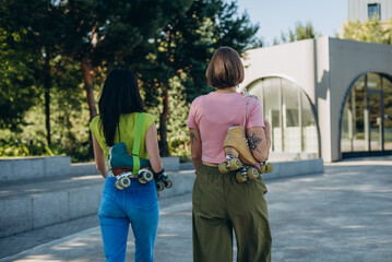 Stylish skater athletes leave open sport plaza walk side by side
