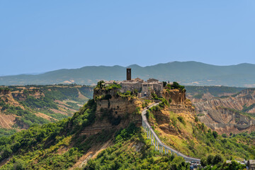  Italy - Bagnoregio - Civita di Bagnoregio - Hilltop medieval village on tuff cliff with long pedestrian bridge over Valle dei Calanchi, panoramic view