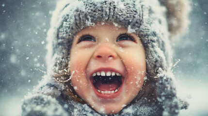 A happy child looking up at falling snow, a laughing kid face in winter, a close-up portrait with snowflakes, joy and wonder concept.