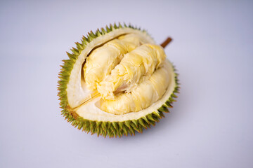 Premium shot of a halved durian fruit, revealing rich creamy yellow pulp and a sharp spiky husk. Fresh tropical exotic fruit isolated on a plain white background