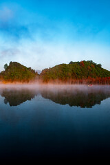 Beautiful scenery of mountains and water reflected in the morning mist