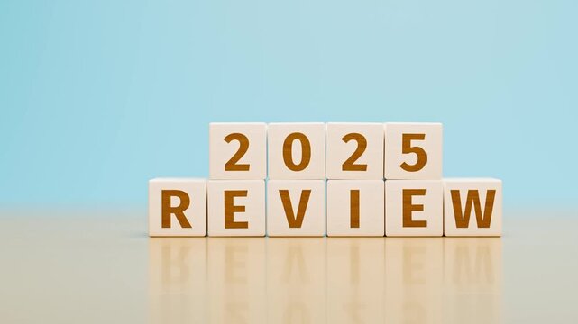 Wooden toy cubes forming the text "2025 REVIEW". Concept for reviewing what happened in the year 2025. Tracking shot.