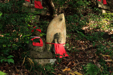 森の中に並ぶ赤い帽子のお地蔵さん

