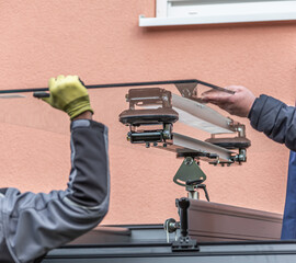 Workers install patio roofing with steel and glass