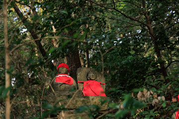 森の中に並ぶ赤い帽子のお地蔵さん

